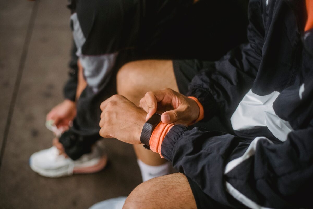 Close-up of a man in athletic wear adjusting a smartwatch, showcasing fitness and technolo
