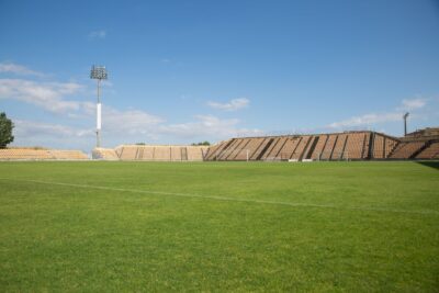 A bright, clear day at an empty football stadium in Portugal, perfect for sports events.
